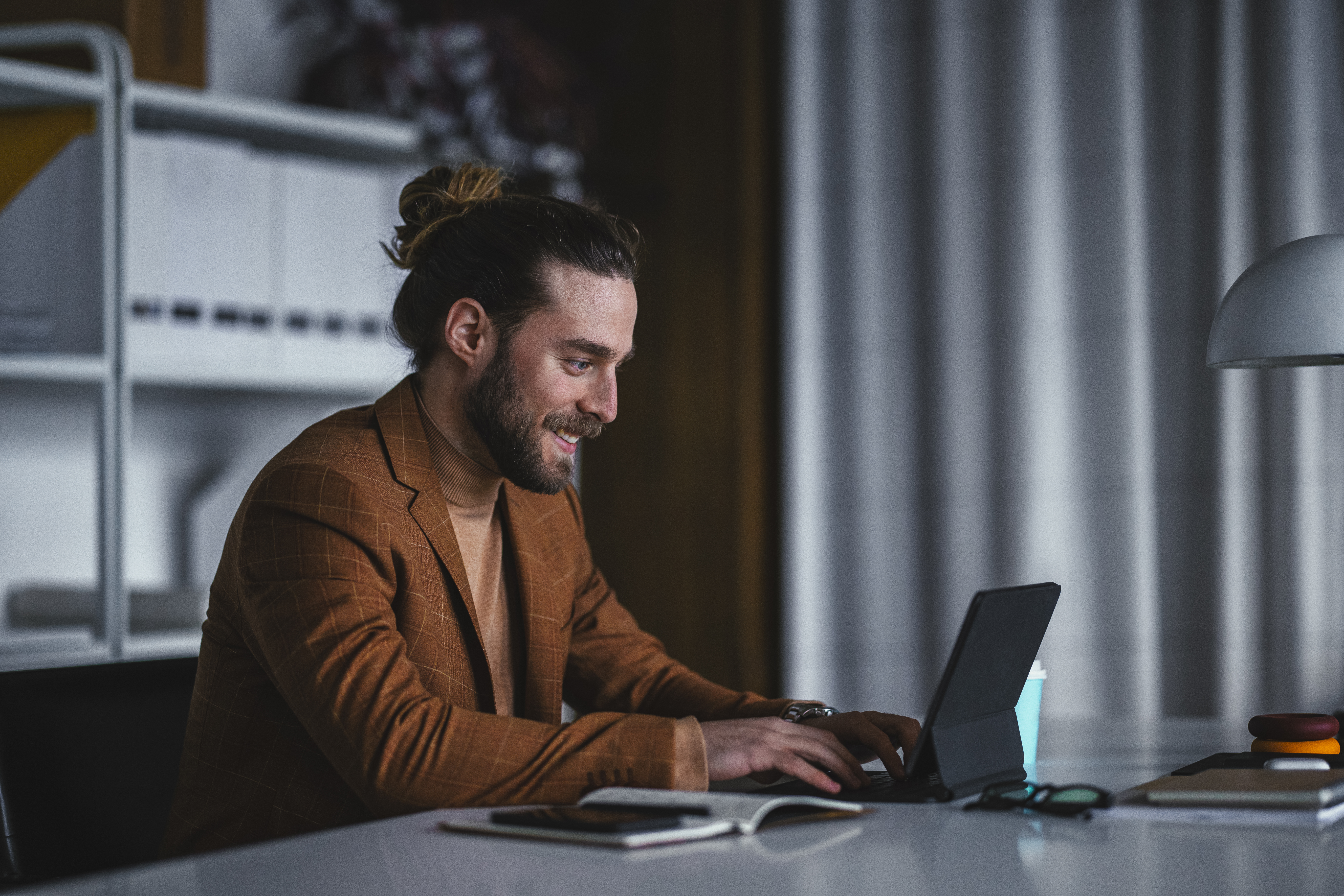 Mann sitzt entspannt mit Tablet und prüft digitale Dokumente – sinnbildlich für ortsunabhängigen Zugriff auf Geschäftspost über einen digitalen Posteingang.